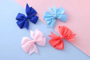 Vue détaillée de quatre nœuds à cheveux en ruban gros-grain bleu et rose avec finitions
