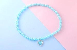 Détail de perles bleu clair et de perles facettées avec un pendentif en forme de cœur