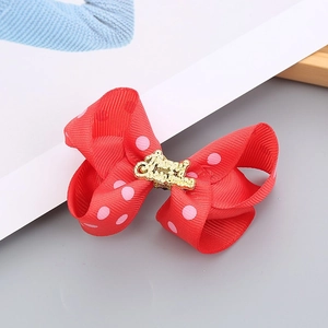 Detail of red polka dot Christmas bow headband with golden Merry Christmas metallic charm