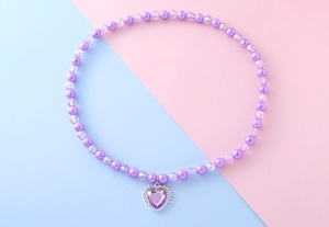 Vue détaillée du collier de perles violettes pour enfants avec un pendentif cœur étincelant