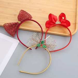Three creative Christmas headbands with red bows and gold Merry Christmas signs