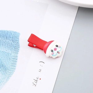 Detalle de pinza navideña para niña con figura de Papá Noel sobre cinta de color rojo
