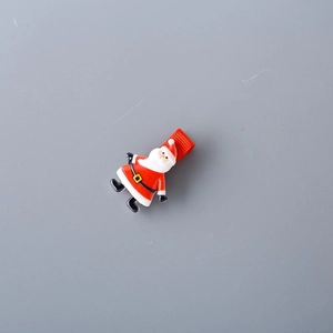 Détail de la pince à cheveux Père Noël pour enfants avec ruban rouge festif