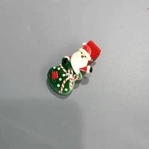 Détail de la pince à cheveux Noël avec Père Noël et petit sac cadeau vert