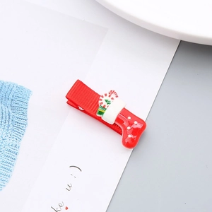 Detalle de pinza roja para el pelo con calcetín navideño 3D y diseño de bastón de caramelo