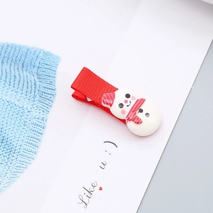 Detalle de la pinza para el pelo de muñeco de nieve navideño con lazo rojo y detalles