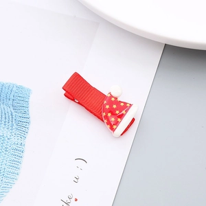 Primer plano de una pinza para el pelo con gorro de Navidad rojo y pompón blanco