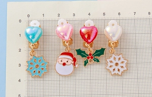 Detailed size view of colorful Christmas ear clips with Santa and snowflake charms