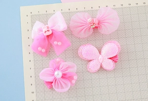 Détail de barrettes à fleurs en gaze rose et papillons pour filles avec perles et résine