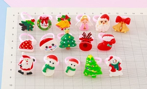 Flat lay of colorful Christmas resin rings featuring Santas and trees on a grid scale