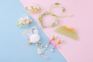 Detail view of floral hair clips and pearl rabbit accessories in a pastel jewelry set