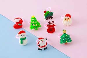 Close-up of kids' Christmas resin rings with Santa, snowman, and reindeer characters