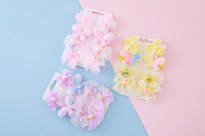 Vue détaillée de six barrettes à fleurs en tulle et papillons sur carte de support