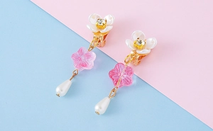 Detail of floral clip-on earrings with resin petals, crystals, and drop pearls