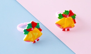 Detail of two adjustable kids Christmas rings featuring yellow bells and red bows