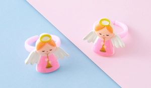 Close-up of two pink angel resin rings with golden wings and open adjustable bands