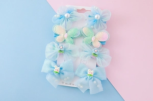 Détail du lot de 8 barrettes à fleurs en tulle bleu et papillons pour petites filles