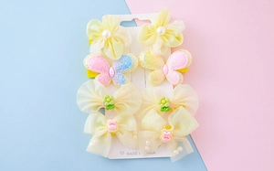 Détail de barrettes à fleurs en mousseline et papillons pour enfants sur carte