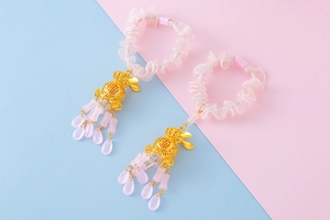 Detail of pink organza hair scrunchies with gold hollow rabbit pendants and drop beads