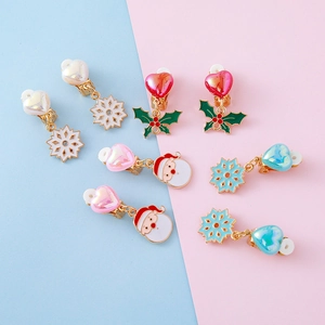 Kids clip-on Christmas earrings set with snowflake and holly designs on a pastel background