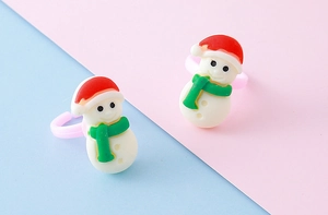 Detail shot of two cute Christmas snowman rings with red hats on pink resin bands
