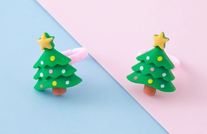 Detail of cute green Christmas tree resin rings with adjustable pink bands for kids