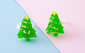 Close-up of two green resin Christmas tree rings with colorful dots and yellow stars