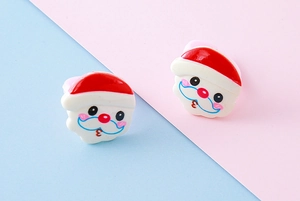 Close-up of colorful resin Santa Claus stud earrings for Christmas holiday accessory