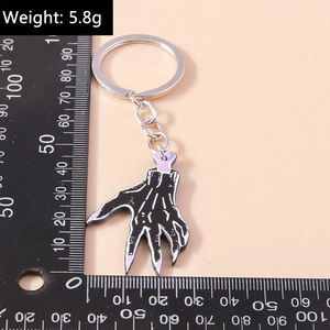 Detailed macro view of black and purple skeleton hand keychain with scale measurement