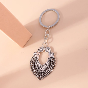 Vintage Silber Herz Schlüsselanhänger mit Ethno-Muster auf rosa Hintergrund