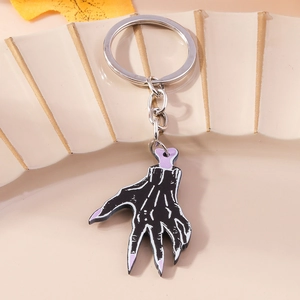 Detailed macro shot of a skeleton hand keychain with purple nails and black alloy details