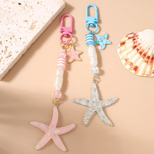 Detail of pink and blue resin starfish keychains with striped beads and faux pearls