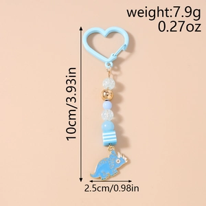 Détail d'un porte-clés perlé tricératops bleu avec mousqueton coeur et dimensions du produit
