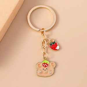 Fashionable strawberry bear keychain with golden ring and enamel charms in 45-degree view