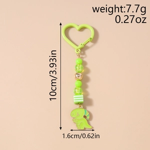 Détail d'un porte-clés dinosaure avec perles et fermoir en forme de cœur, longueur 10cm