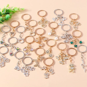 Flat lay of diverse animal and heart keychains with crystal rhinestones on pink background