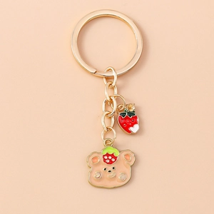 Cute golden metal keychain with enamel bear wearing strawberry hat and crystal charm