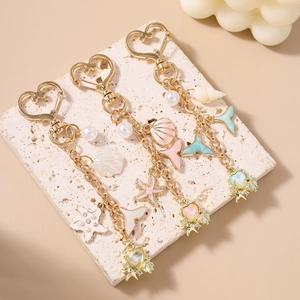 Golden ocean theme keychain with starfish, seashells, and pearls for stylish bag decoration