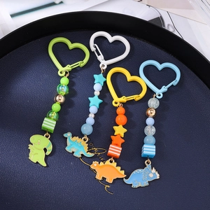Lot de quatre porte-clés dinosaures colorés en émail avec breloques perlées