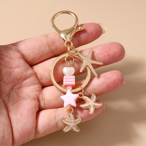 Detailansicht Ozean Schlüsselanhänger in Gold mit rosa Seestern und Streifenperle