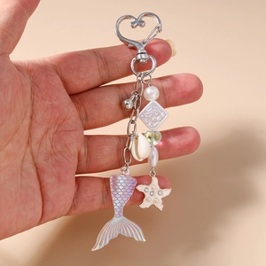 Détail du porte-clés queue de sirène avec perles, étoile de mer et pendentif irisé