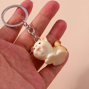 Detailed view of a cute ginger white resin cat keychain accessory held in hand