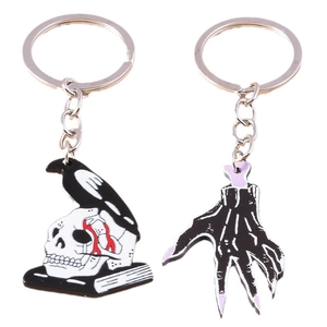 Gothic metal enamel keychains featuring a raven on a skull and a purple skeleton hand charm