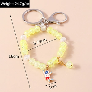 Detail of beaded astronaut keychain with yellow crackle beads and silver lobster clasp