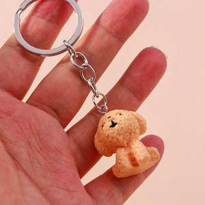Detailed view of an orange poodle dog keychain with a textured finish held in hand