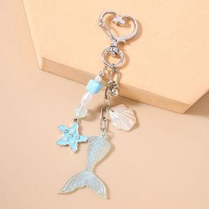 Détail d'un porte-clés marin avec étoile de mer coquillage et queue de poisson dégradée