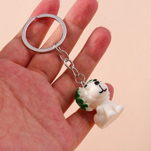 Hand holding a cute white cartoon dog keychain with green hair and silver ring