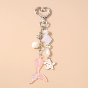 Détail d'un porte-clés queue de poisson rose et étoile de mer avec cœur et perles
