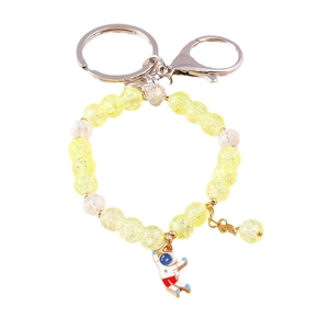 Astronaut keychain with yellow beaded ring and blue cartoon spaceman pendant charm