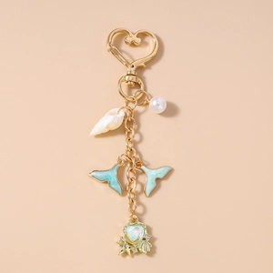 Detailed view of ocean theme keychain with gold starfishes, shell and blue fishtails